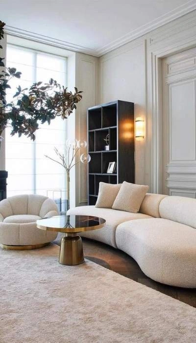 Modern beige curved sofa and round chair in bright living room