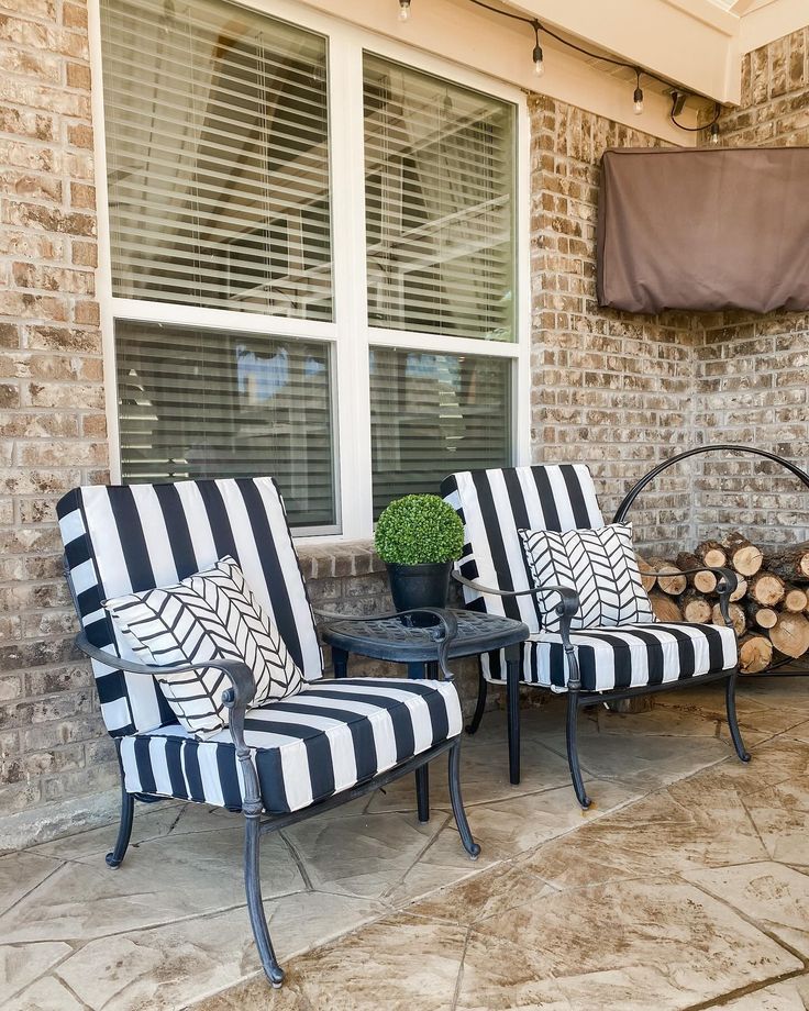 Black and white striped patio chairs with decorative pillows and small table