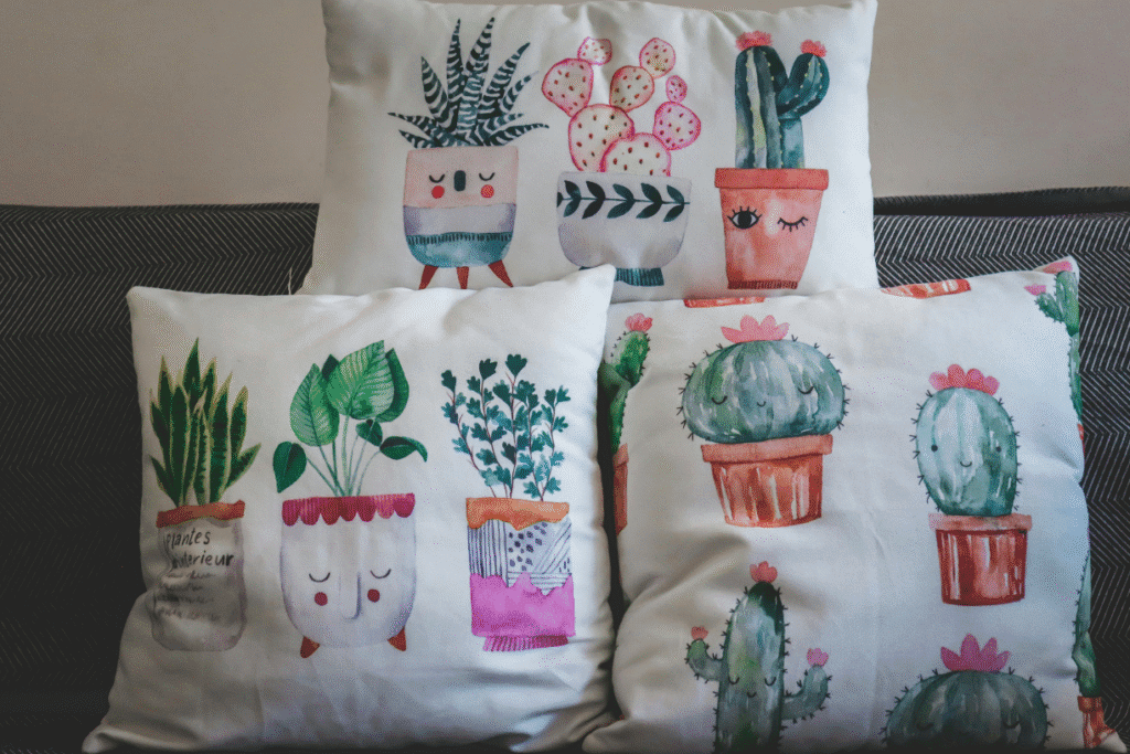 Decorative throw pillows with cute watercolor cactus and plant illustrations