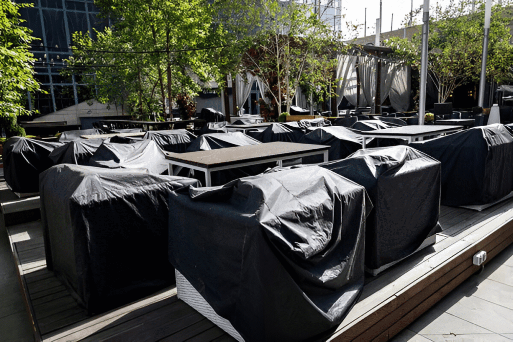 Outdoor furniture covered with black protective covers