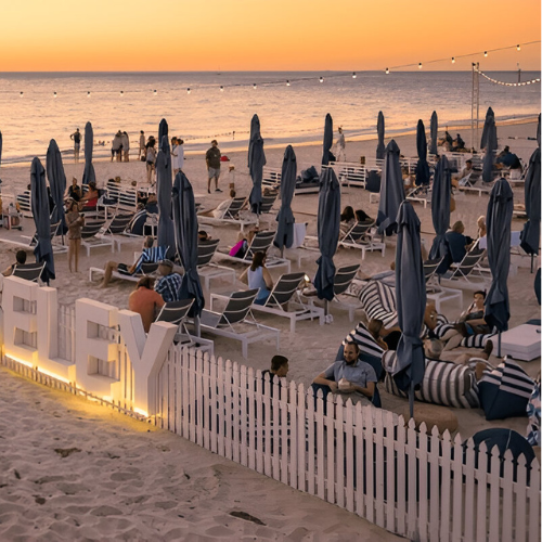 Beach lounge area with umbrellas and seating at sunset