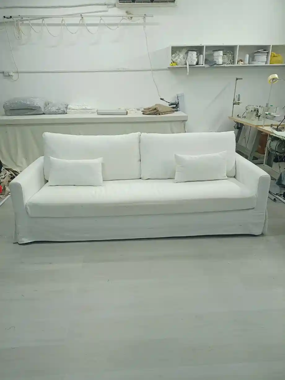 White upholstered three-seater sofa after reupholstery in Dubai workshop