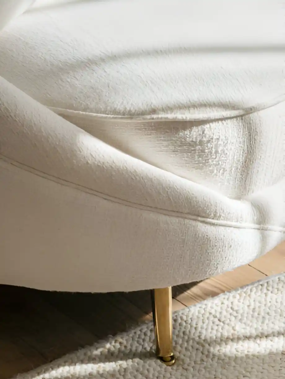 White upholstered chair with gold legs, showcasing soft fabric texture.