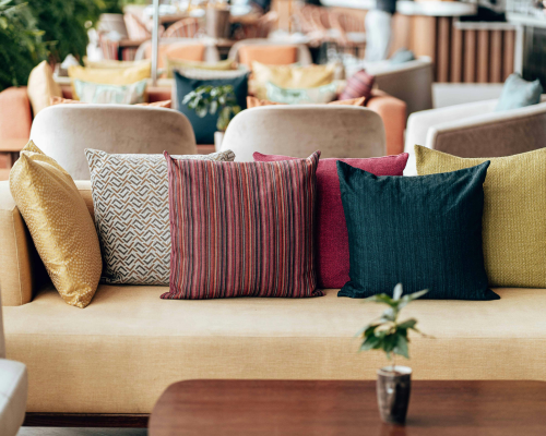 Modern beige sofa with assorted colorful throw pillows in stylish lounge area
