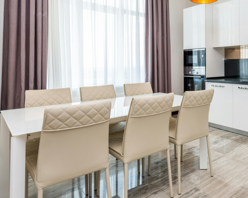 Modern dining area with white table and beige leather chairs