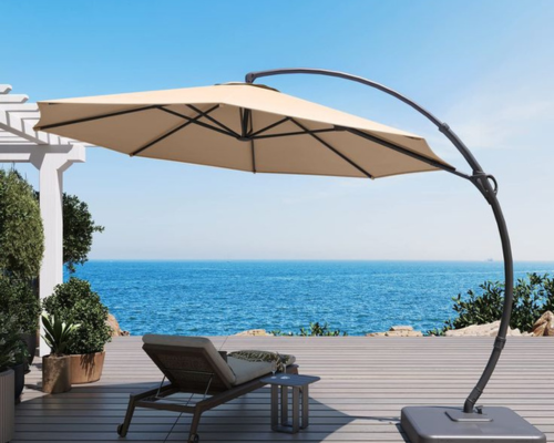 Large beige cantilever umbrella shading lounge chair on oceanfront deck