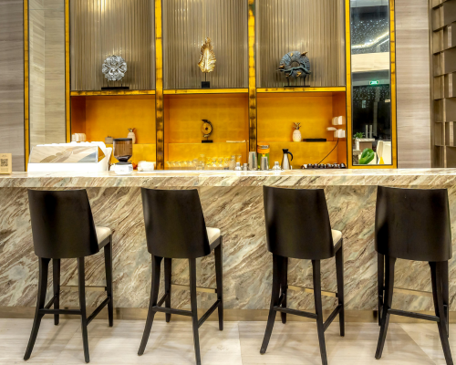 Modern bar counter with four black bar stools and decorative shelves