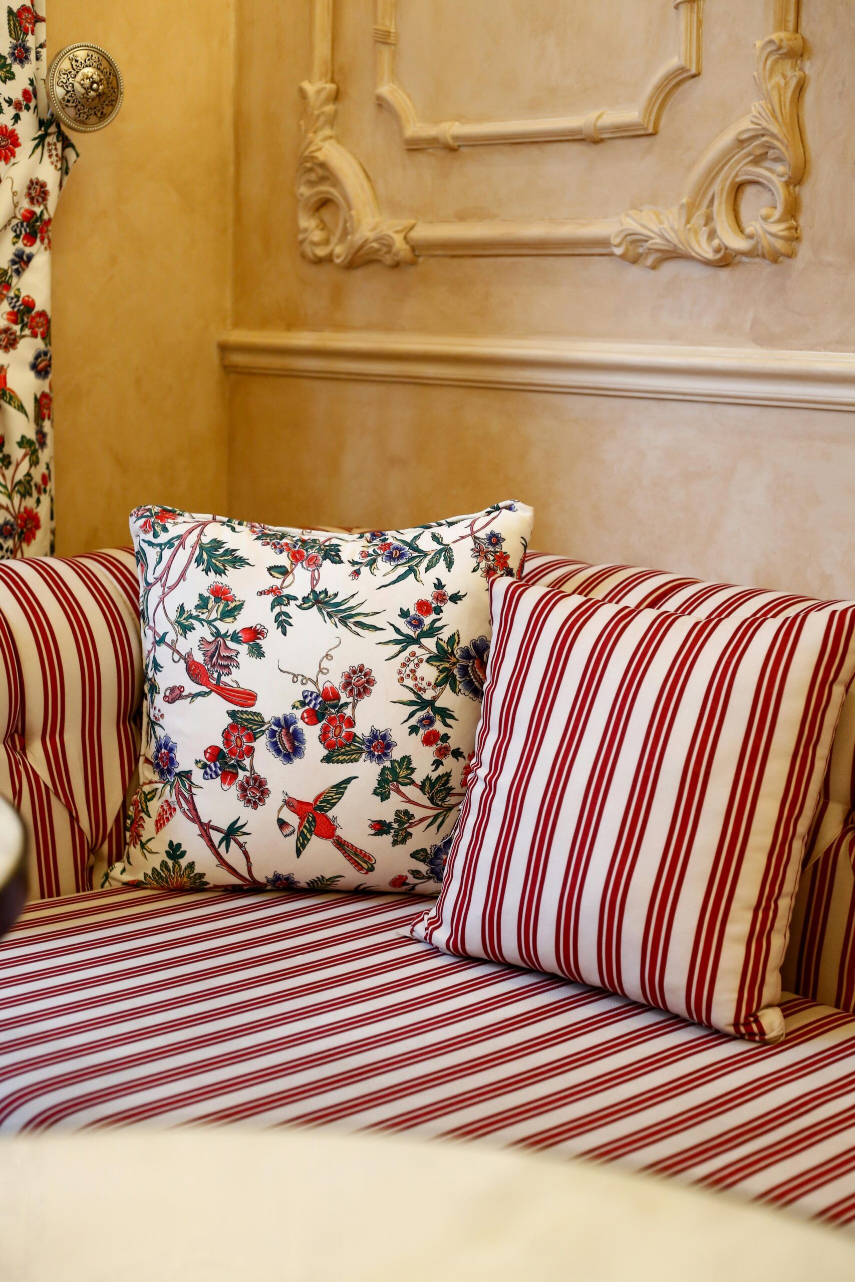Striped sofa with floral and striped cushions in elegant room