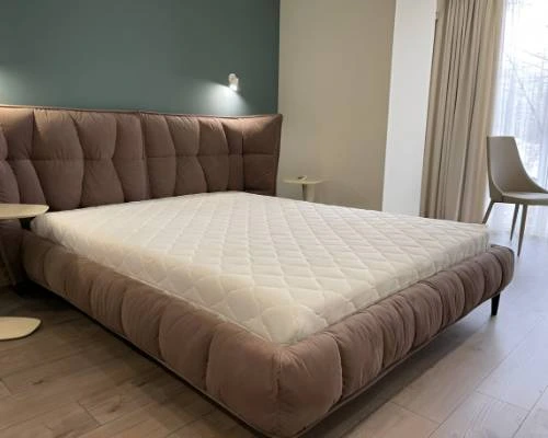 Modern upholstered bed with a quilted mattress