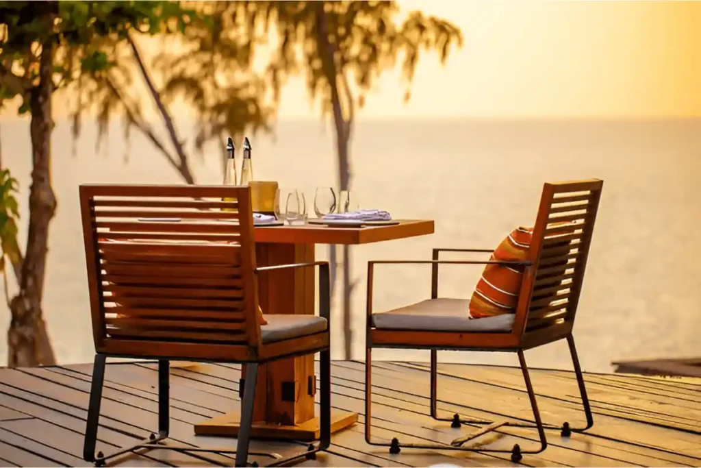 Outdoor dining setup by the sea at sunset
