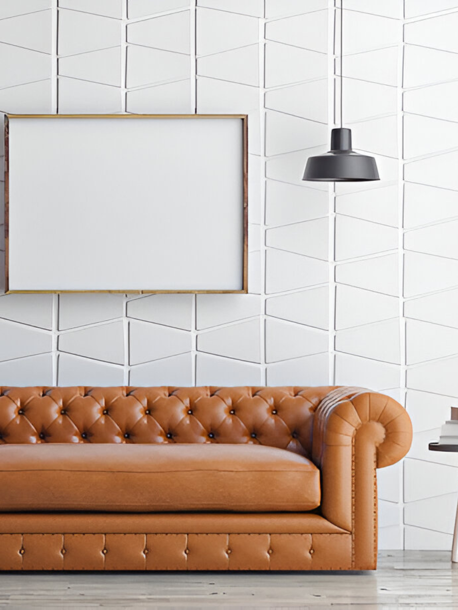 Brown leather Chesterfield sofa with blank wall art and modern pendant light