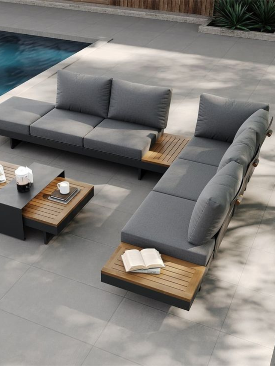 Modern outdoor patio furniture with gray cushions and wooden accents by the pool